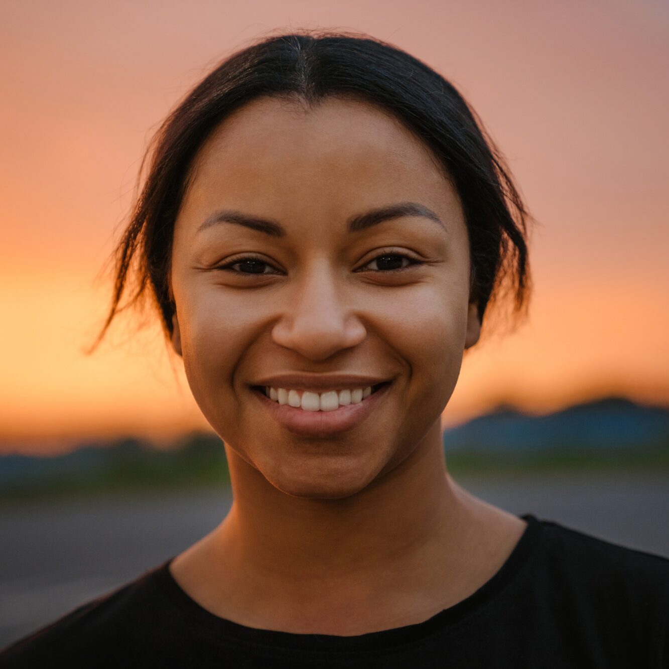 Black brunette woman smiling and looking at camera