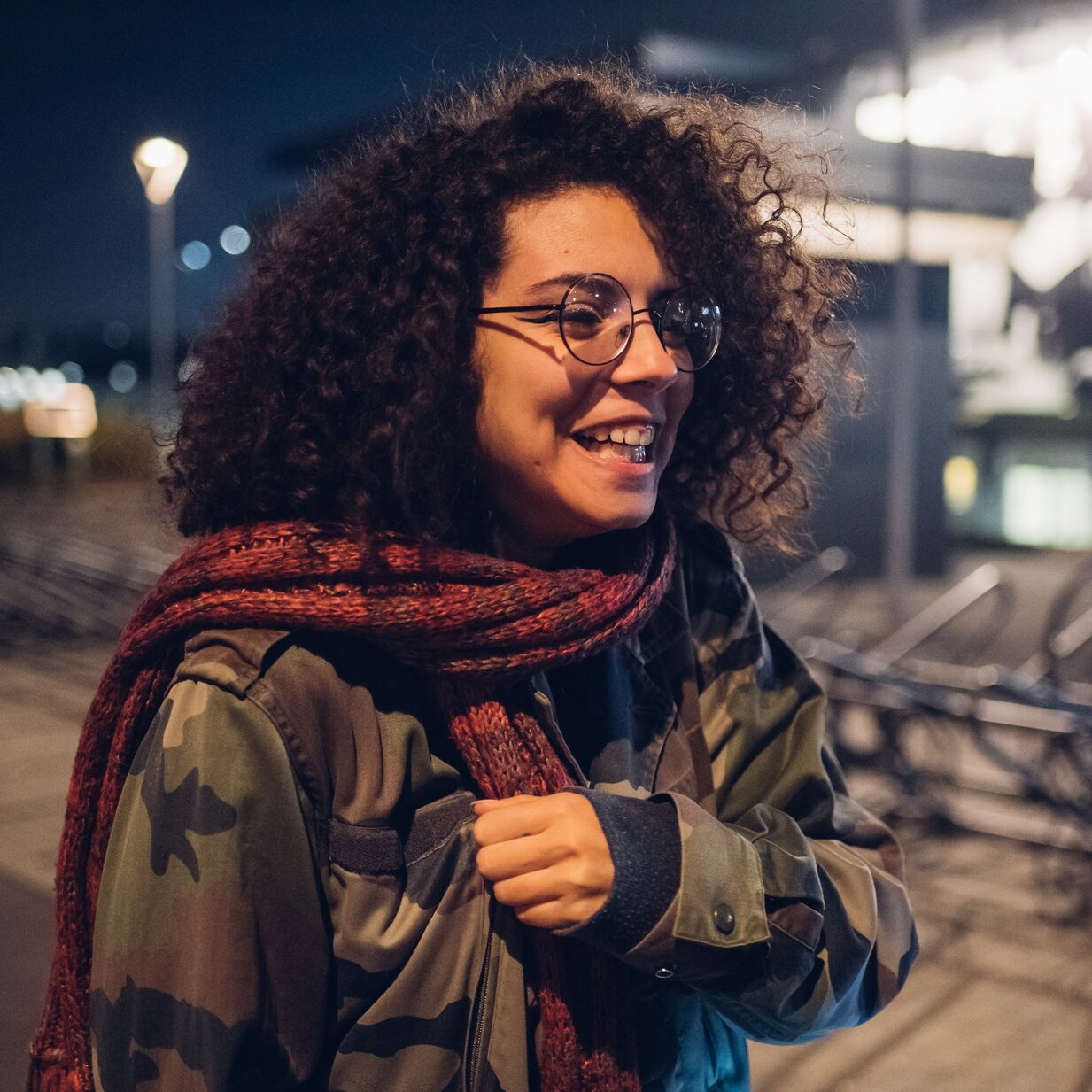 curly brunette girl smiling in the street